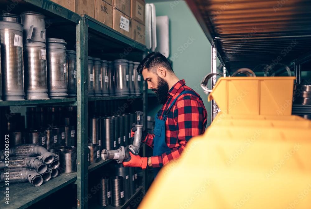 Handsome adult man working in car and truck spare parts warehouse. Handsome adult man working in car and truck spare parts warehouse.
