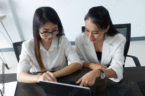 Close up view of female working with tablet on white table in office room. photo