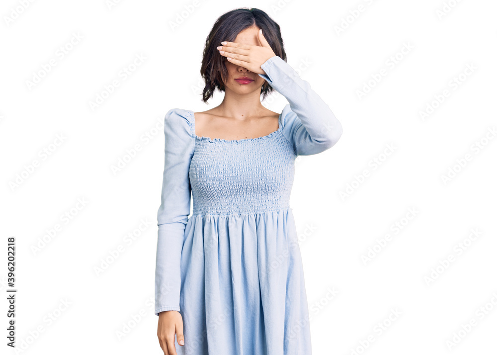 Young beautiful girl wearing casual clothes covering eyes with hand, looking serious and sad. sightless, hiding and rejection concept Young beautiful girl wearing casual clothes covering eyes with hand, looking serious and sad. sightless, hiding and rejection concept