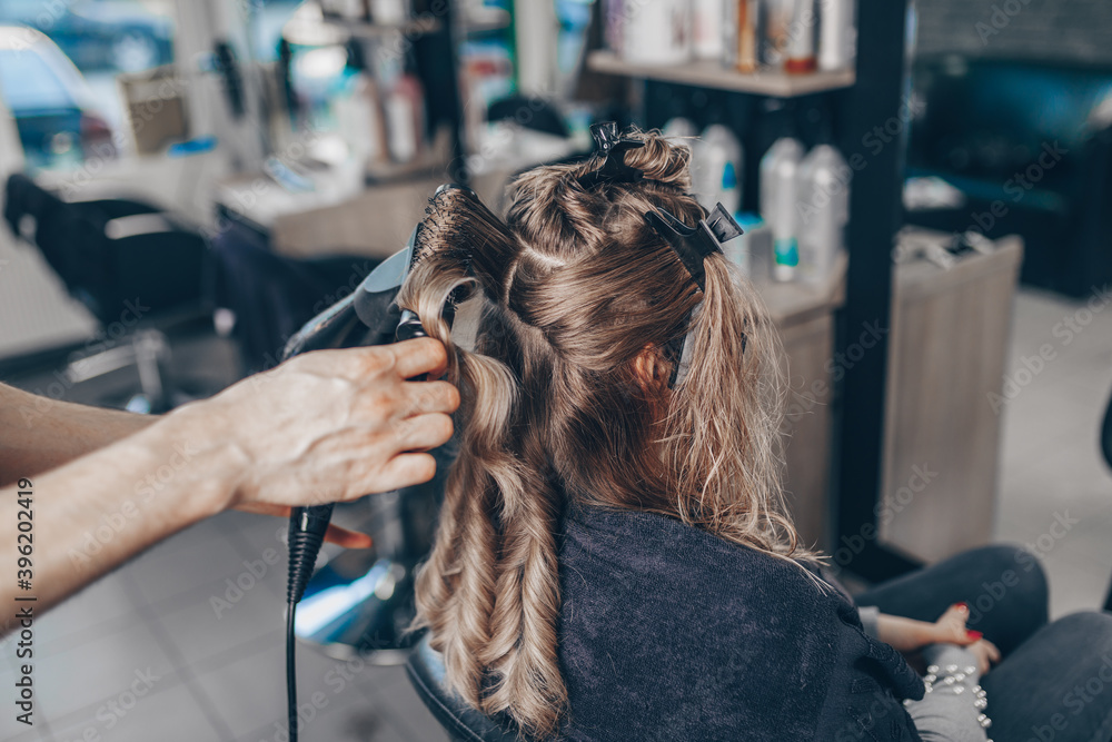 Naklejka premium Beautiful hairstyle of woman after dyeing hair and making highlights in hair salon.