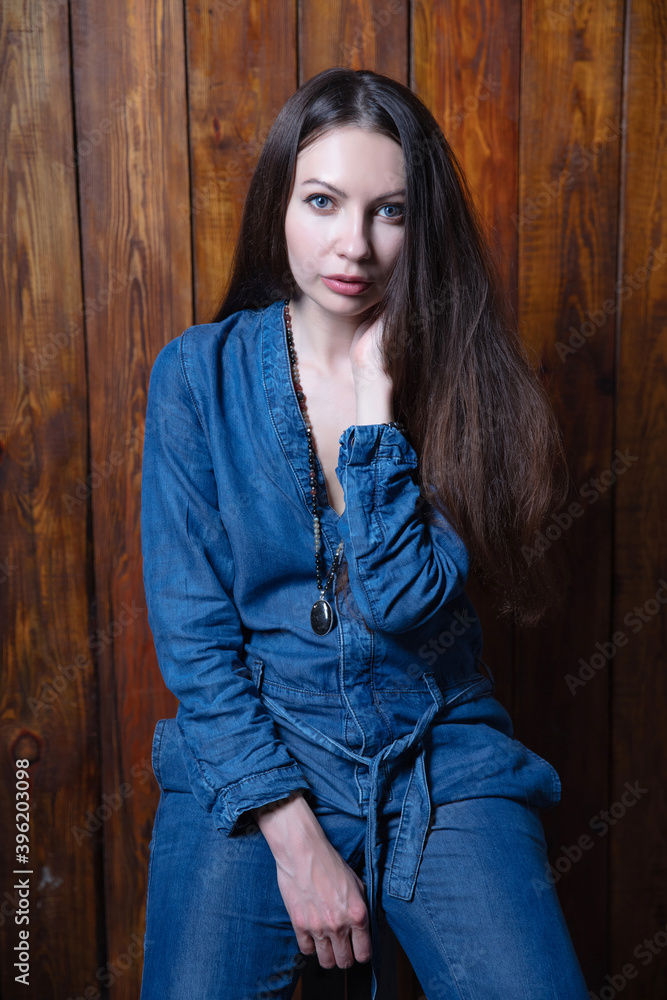 Fototapeta premium Beautiful brunette dressed in denim overalls