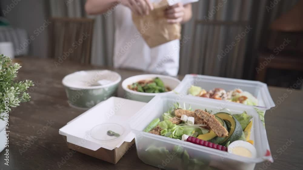 Asian women setting up food table, preparing healthy meals to the table, take away delivery food ordering food online, keep away, house dinner party, lunch box, easy simple home convenience lifestyle Asian women setting up food table, preparing healthy meals to the table, take away delivery food ordering food online, keep away, house dinner party, lunch box, easy simple home convenience lifestyle