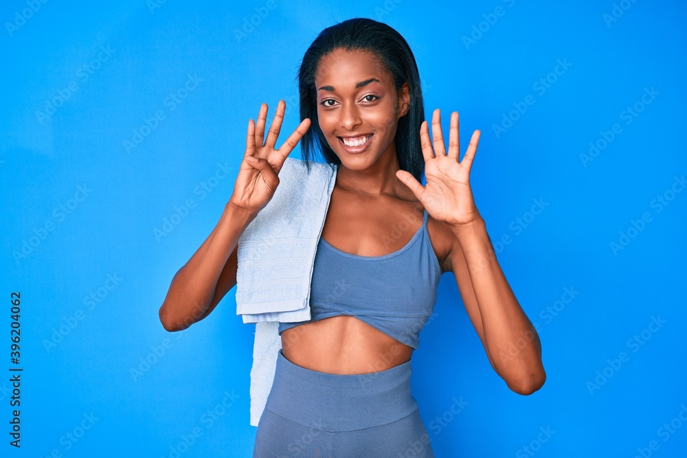 Young african american woman wearing sportswear showing and pointing up with fingers number nine while smiling confident and happy. Young african american woman wearing sportswear showing and pointing up with fingers number nine while smiling confident and happy.