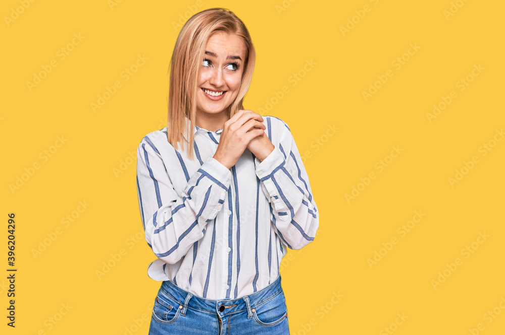 Beautiful caucasian woman wearing casual clothes laughing nervous and excited with hands on chin looking to the side Beautiful caucasian woman wearing casual clothes laughing nervous and excited with hands on chin looking to the side