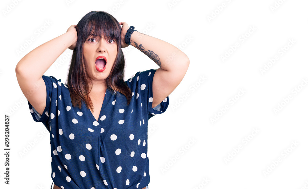 Young plus size woman wearing casual clothes crazy and scared with hands on head, afraid and surprised of shock with open mouth Young plus size woman wearing casual clothes crazy and scared with hands on head, afraid and surprised of shock with open mouth