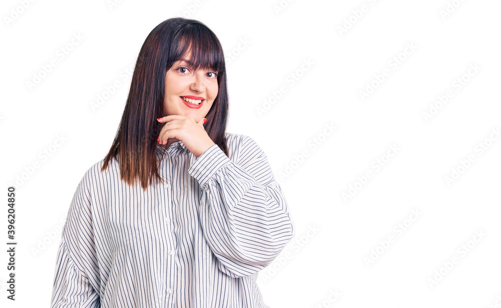 Young plus size woman wearing casual clothes looking confident at the camera smiling with crossed arms and hand raised on chin. thinking positive. Young plus size woman wearing casual clothes looking confident at the camera smiling with crossed arms and hand raised on chin. thinking positive.