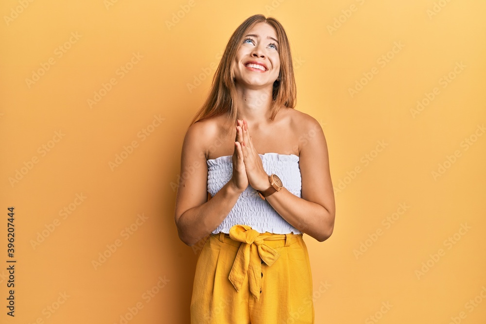 Beautiful young blonde woman wearing casual summer clothes begging and praying with hands together with hope expression on face very emotional and worried. begging. Beautiful young blonde woman wearing casual summer clothes begging and praying with hands together with hope expression on face very emotional and worried. begging.
