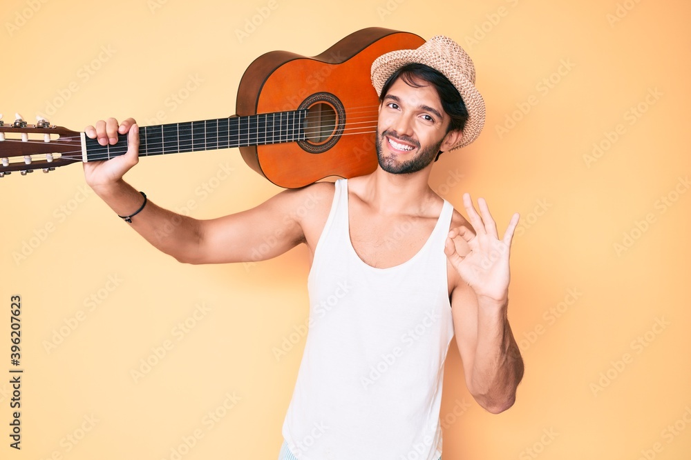 Handsome hispanic man with classical guitar doing ok sign with fingers, smiling friendly gesturing excellent symbol Handsome hispanic man with classical guitar doing ok sign with fingers, smiling friendly gesturing excellent symbol
