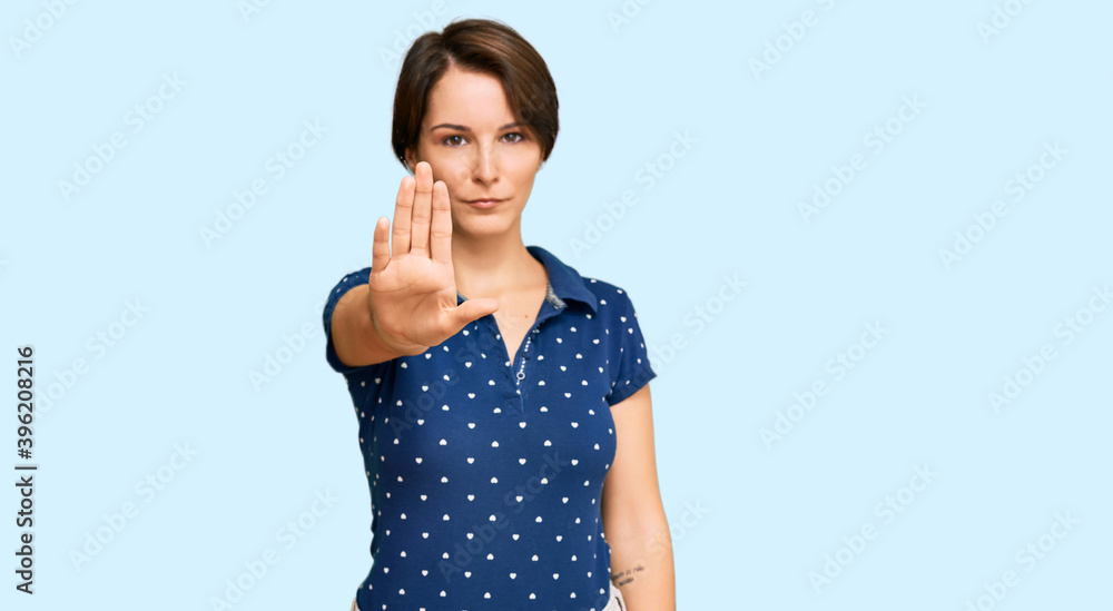 Young brunette woman with short hair wearing casual clothes doing stop sing with palm of the hand. warning expression with negative and serious gesture on the face. Young brunette woman with short hair wearing casual clothes doing stop sing with palm of the hand. warning expression with negative and serious gesture on the face.