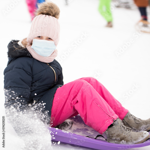 Petite fille sur traîneau avec masque respiratoire