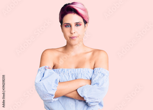 Young beautiful woman with pink hair wearing casual clothes skeptic and nervous, disapproving expression on face with crossed arms. negative person.
