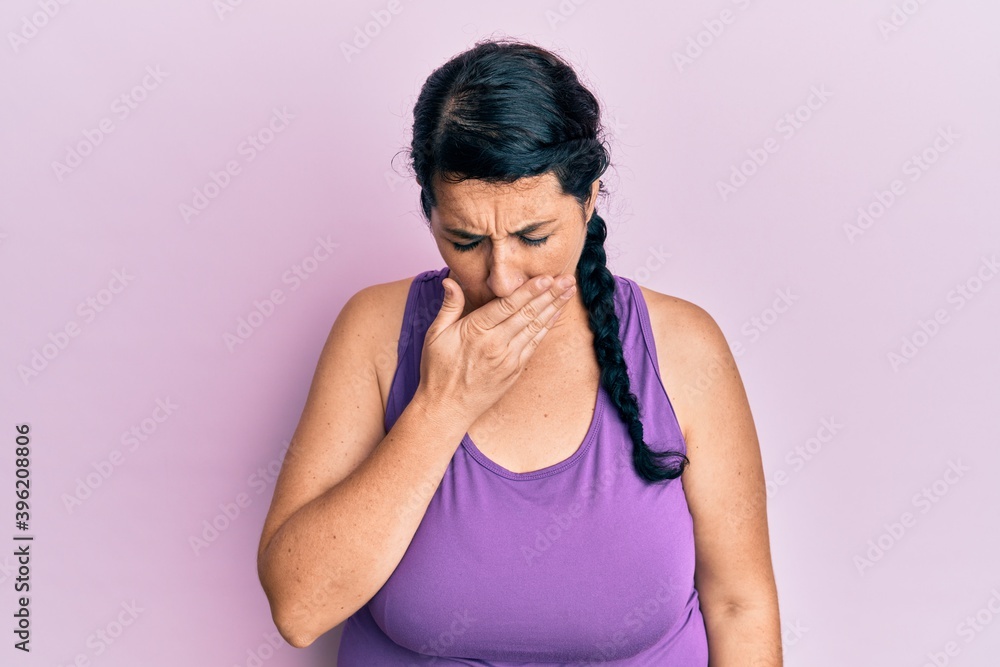Plus size brunette woman wearing sportswear feeling unwell and coughing as symptom for cold or bronchitis. health care concept.