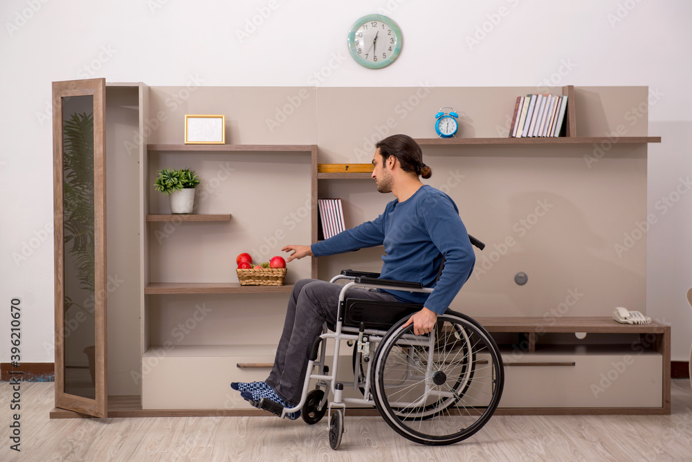 Young man in wheel-chair suffering at home Young man in wheel-chair suffering at home