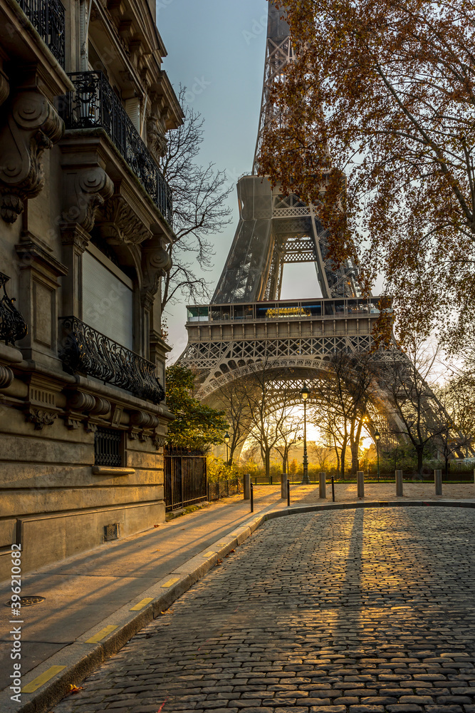 Paris, France - November 26, 2020: A back alley in Paris showcasing the architecture of the buildings with the Eiffel Tower in the background at sunset Paris, France - November 26, 2020: A back alley in Paris showcasing the architecture of the buildings with the Eiffel Tower in the background at sunset