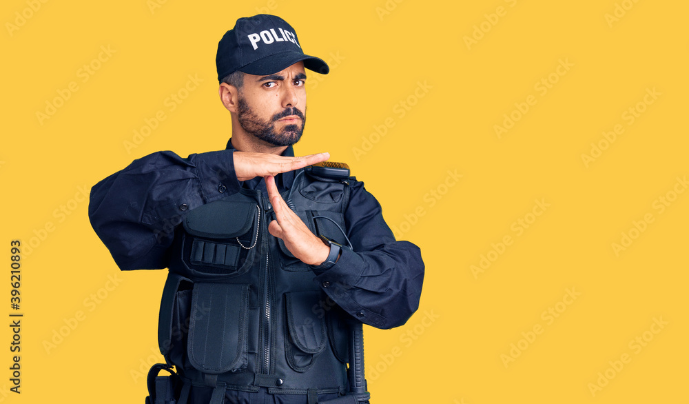 Young hispanic man wearing police uniform doing time out gesture with hands, frustrated and serious face Young hispanic man wearing police uniform doing time out gesture with hands, frustrated and serious face