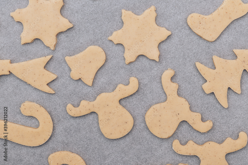 Raw gingerbread cookies on the white baking sheet.