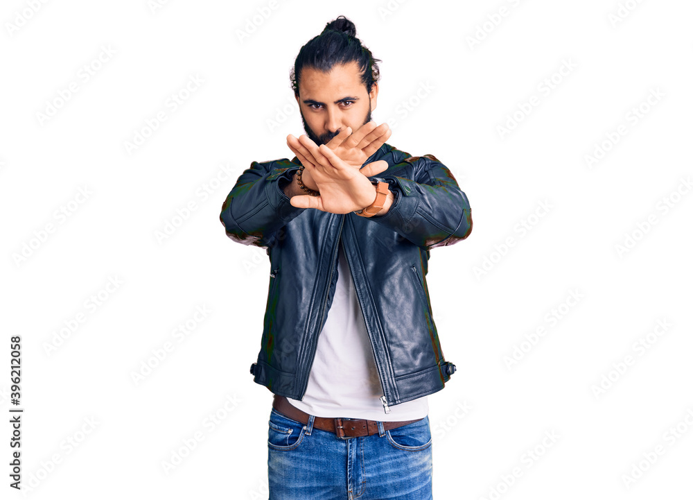 Young arab man wearing casual leather jacket rejection expression crossing arms and palms doing negative sign, angry face Young arab man wearing casual leather jacket rejection expression crossing arms and palms doing negative sign, angry face