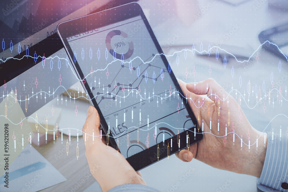 Double exposure of man's hands holding and using a phone and financial graph drawing. Analysis concept. Double exposure of man's hands holding and using a phone and financial graph drawing. Analysis concept.