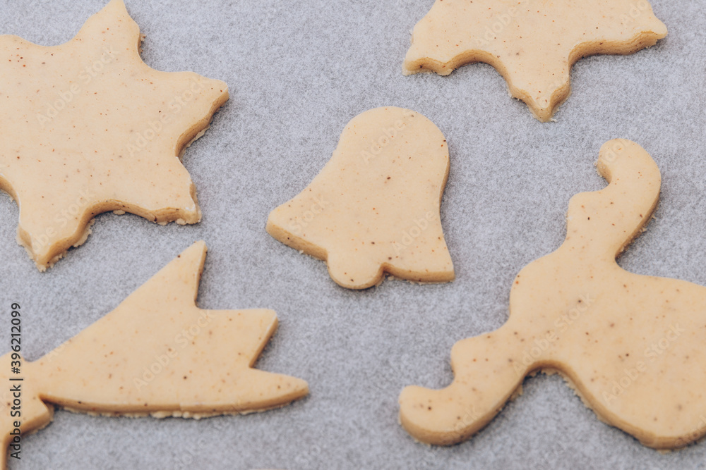 Raw gingerbread cookies on the white baking sheet.