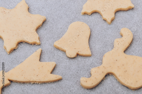 Raw gingerbread cookies on the white baking sheet.