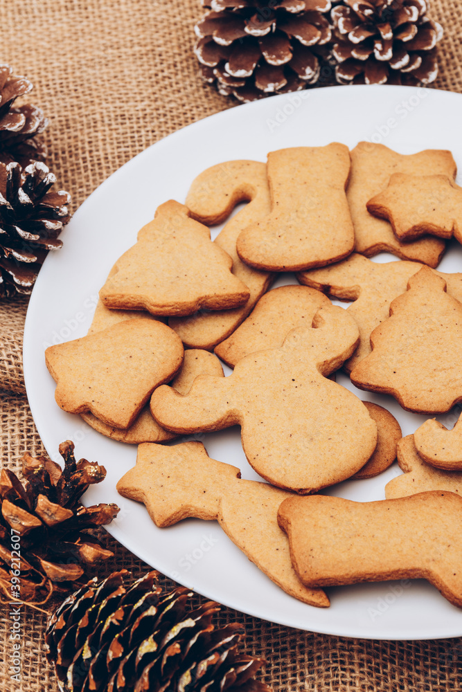 Tasty Christmas gingerbread cookies on the white plate on a sackcloth. Tasty Christmas gingerbread cookies on the white plate on a sackcloth.