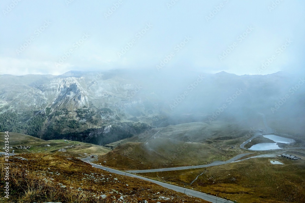 Beautiful alpine mountains, Austria. Fresh clean air, nature background. On the tops of the mountains lies snow all year round. Selective focus. The fog hides the peaks of the mountains, out of focus.