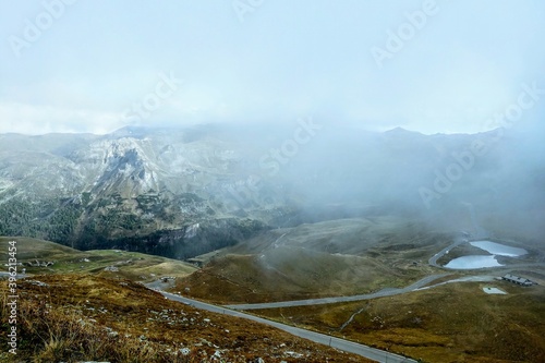 Beautiful alpine mountains, Austria. Fresh clean air, nature background. On the tops of the mountains lies snow all year round. Selective focus. The fog hides the peaks of the mountains, out of focus.