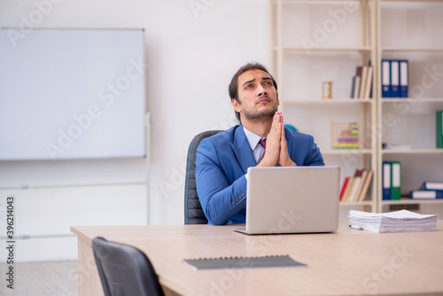 Young male employee sitting in the office in front of whiteboard