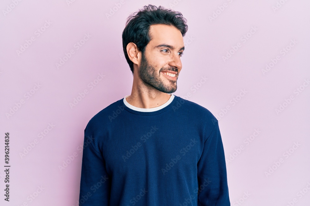 Young hispanic man wearing casual clothes looking to side, relax profile pose with natural face and confident smile. Young hispanic man wearing casual clothes looking to side, relax profile pose with natural face and confident smile.