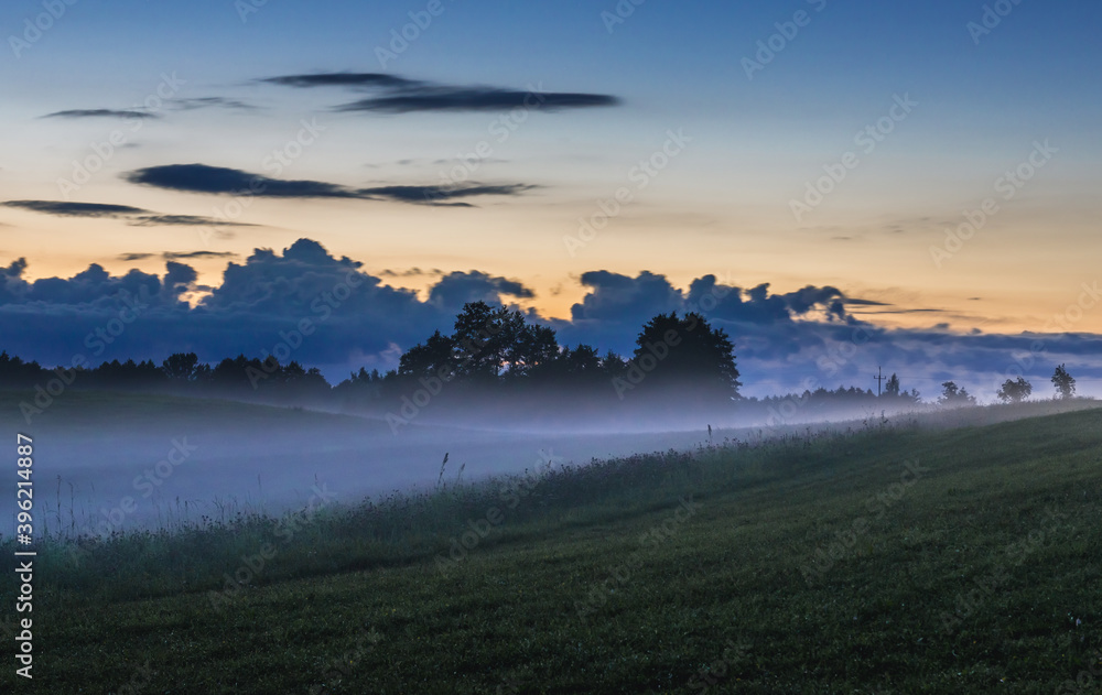 Obraz premium Fog rising over fields near Jeziorowskie village, Masuria region of Poland