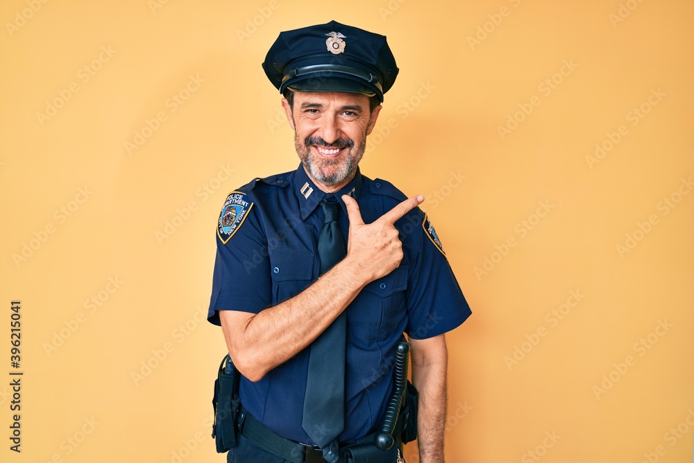 Middle age hispanic man wearing police uniform cheerful with a smile on face pointing with hand and finger up to the side with happy and natural expression Middle age hispanic man wearing police uniform cheerful with a smile on face pointing with hand and finger up to the side with happy and natural expression