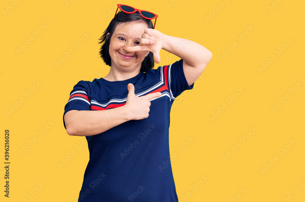 Brunette woman with down syndrome wearing casual clothes smiling making frame with hands and fingers with happy face. creativity and photography concept. Brunette woman with down syndrome wearing casual clothes smiling making frame with hands and fingers with happy face. creativity and photography concept.