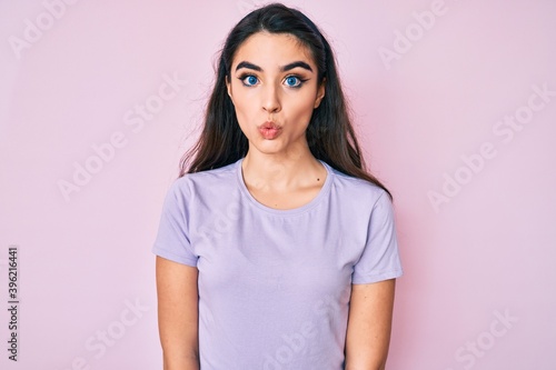 Brunette teenager girl wearing casual clothes scared and amazed with open mouth for surprise, disbelief face