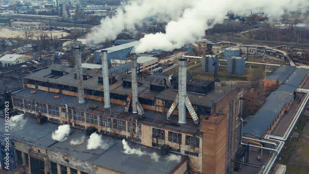 Old brick thermal power plant (CHP) with smoking chimneys. Aerial view Old brick thermal power plant (CHP) with smoking chimneys. Aerial view