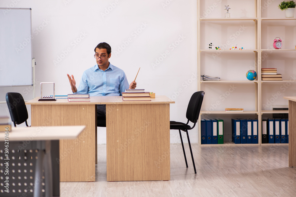 Young male teacher in the classroom Young male teacher in the classroom