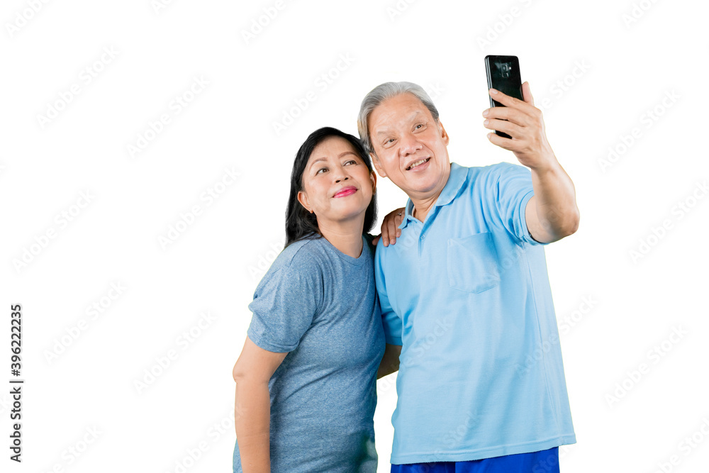 Romantic old couple taking a selfie photo on studio