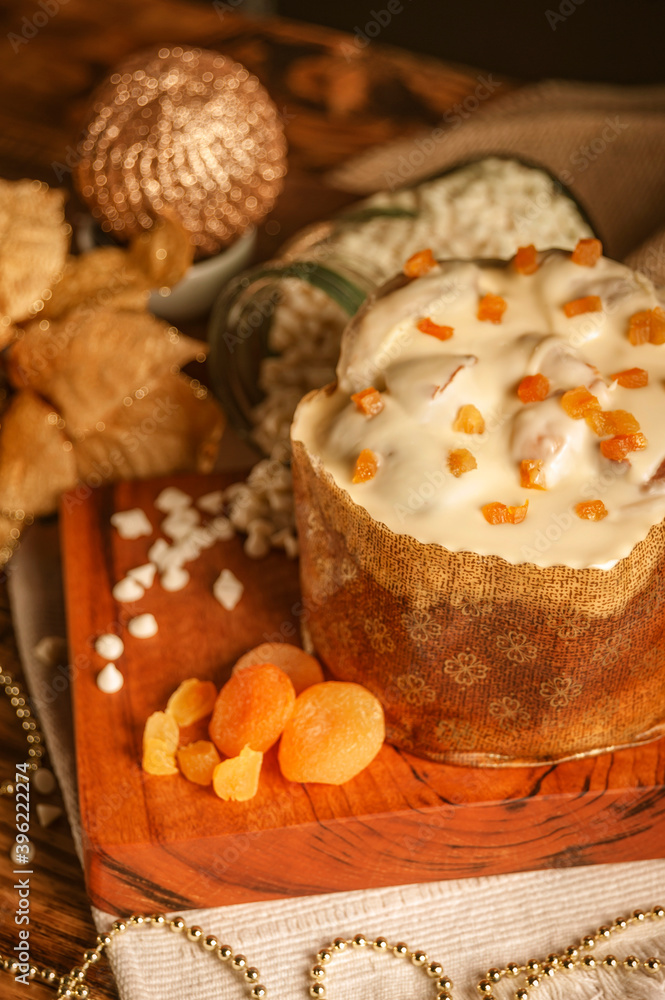 White chocolate panettone with dried apricot on wooden table with christmas ornaments