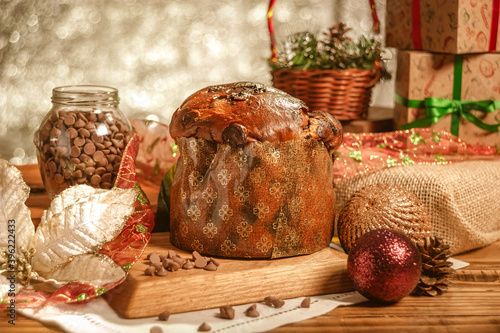 Fototapeta Naklejka Na Ścianę i Meble -  Chocolate panettone  on wooden table with christmas ornaments