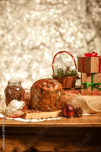 Chocolate panettone on wooden table with christmas ornaments