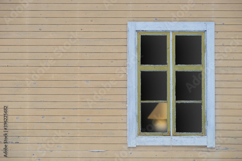 weathered wood and window with lamp inside