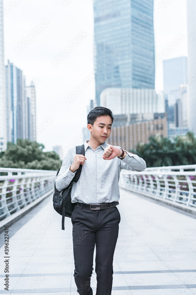 Asian business people walking while watching watch Asian business people walking while watching watch