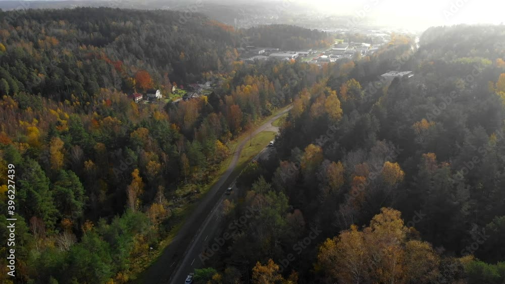 Aerial flying backwards shot of road in a valley during autumn season Aerial flying backwards shot of road in a valley during autumn season