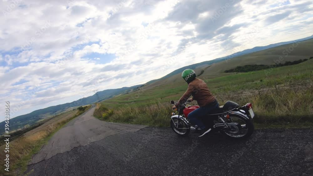 Camera car shot. Man riding red motorcycle in beautiful landscape in Tuscany, Italy. Volterra. Camera car shot. Man riding red motorcycle in beautiful landscape in Tuscany, Italy. Volterra.