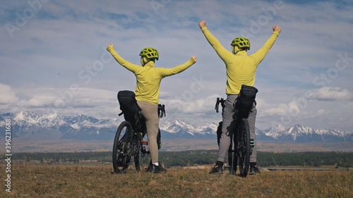 The man and woman travel on mixed terrain cycle touring with bikepacking. The love couple journey with tent in with bicycle bags. Stylish sportswear. photo