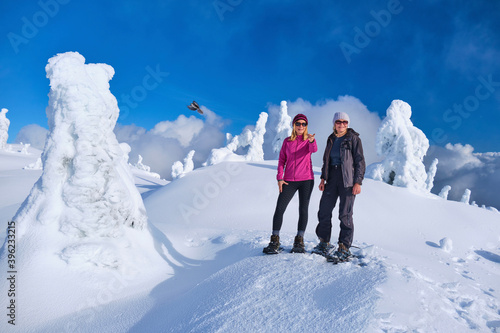 Group of people snowshoeing among snowy white trees on Mount Seymour near Vancouver. British Columbia. Canada 
