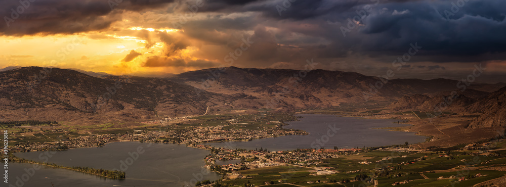 Aerial Panoramic View of a Small Touristic Town. Dramatic Sunset Sky Art Render. Taken in Osoyoos, British Columbia, Canada.