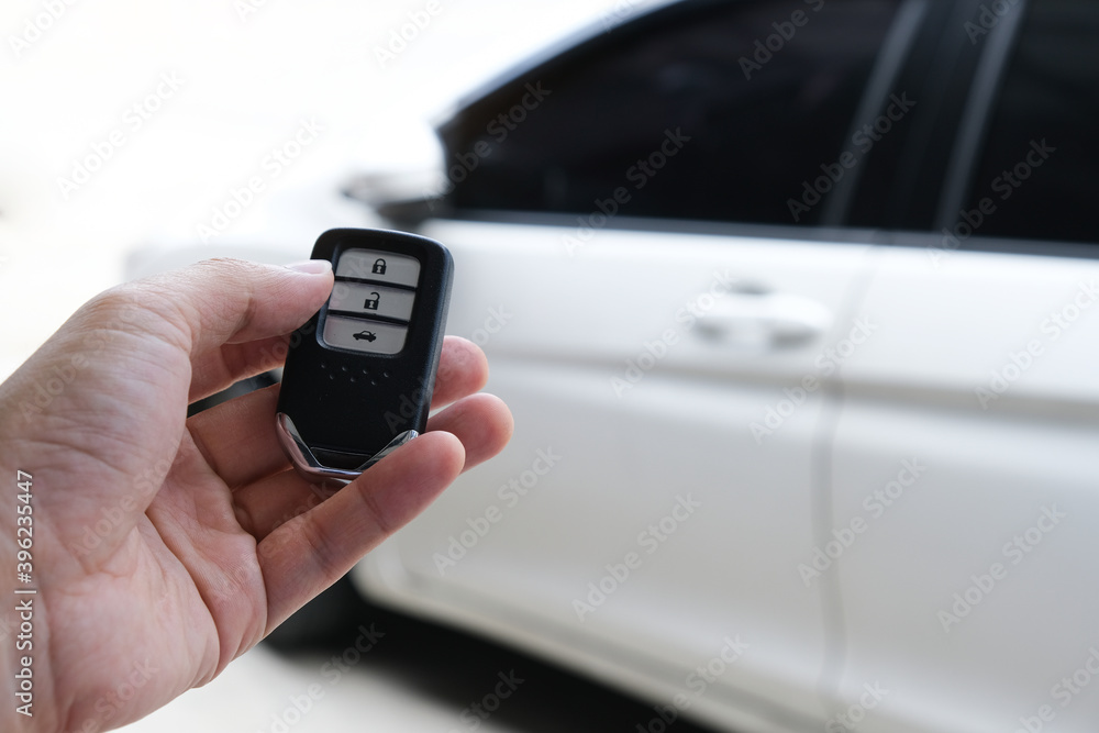 Man hand holding the car remote, he push the remote control to open the car door Man hand holding the car remote, he push the remote control to open the car door