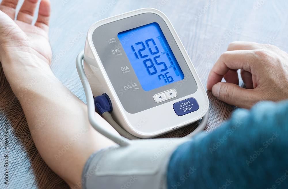 Man check blood pressure monitor and heart rate monitor with digital pressure gauge. Health care and Medical concept Man check blood pressure monitor and heart rate monitor with digital pressure gauge. Health care and Medical concept