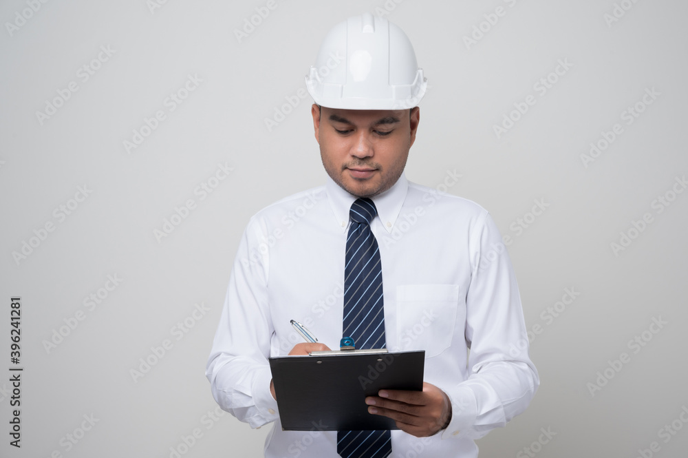 Asian manager civil engineer in uniform hard hat holding clipboard working in studio isolated white background. Asian manager civil engineer in uniform hard hat holding clipboard working in studio isolated white background.