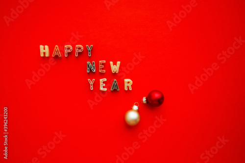 Happy New Year lettering on a bright red background with a copy of the space. Greeting card. The concept of the celebration. Paste of letters of the alphabet.